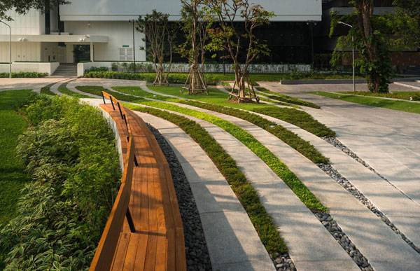 Custom bench seating follows the theme of the overall design and provides a touch of color and highlight for the primary, bounding curve. Image courtesy of Landscape Architects of Bangkok 